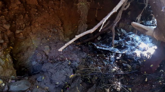 Flusswasser versickert in einem Loch und fließt unterirdisch weiter