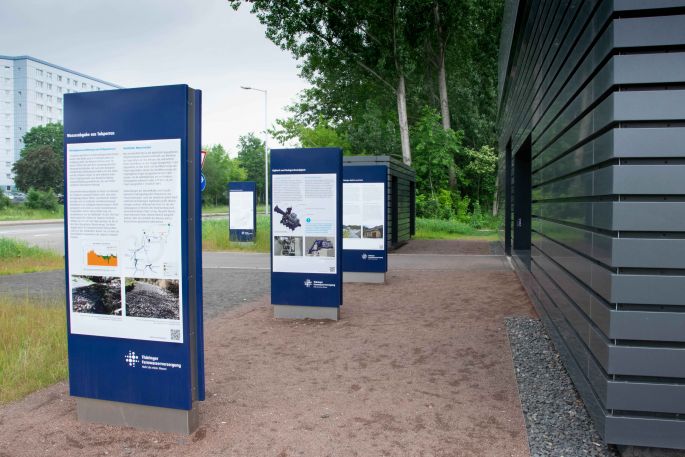 Infostelen zur Besucherinformation stehen vor der Wasserkraftanlage